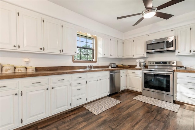 kitchen with a sink, white cabinetry, appliances with stainless steel finishes, and dark wood-style floors