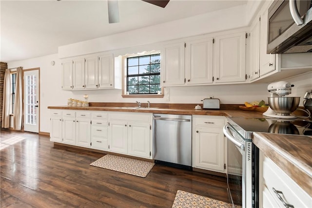 kitchen featuring white cabinetry, appliances with stainless steel finishes, a sink, and dark wood-type flooring