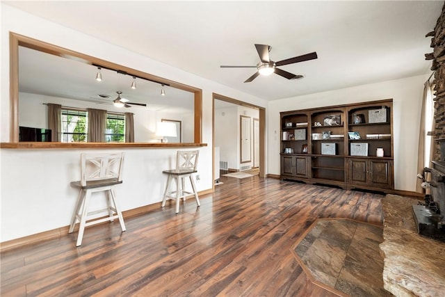 living room with baseboards, ceiling fan, and wood finished floors