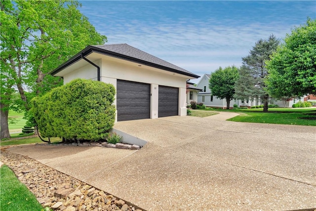view of home's exterior with stucco siding, a yard, driveway, and a garage