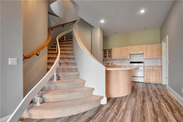 stairs with recessed lighting, baseboards, and wood finished floors