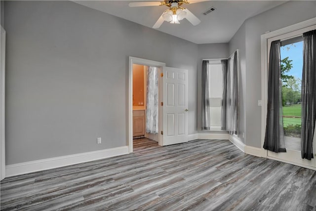 unfurnished bedroom with baseboards, a ceiling fan, wood finished floors, and visible vents