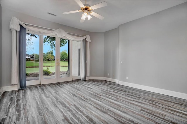 spare room with visible vents, baseboards, and wood finished floors