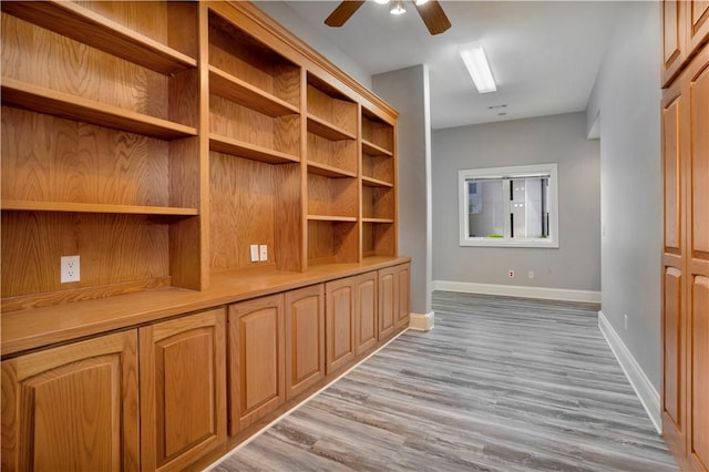 hallway featuring light wood-style floors and baseboards