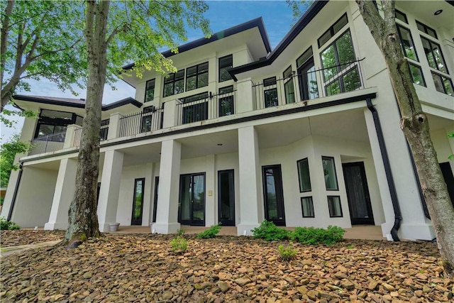 back of property featuring stucco siding and a balcony