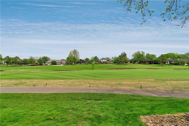 view of community with a residential view, view of golf course, and a yard