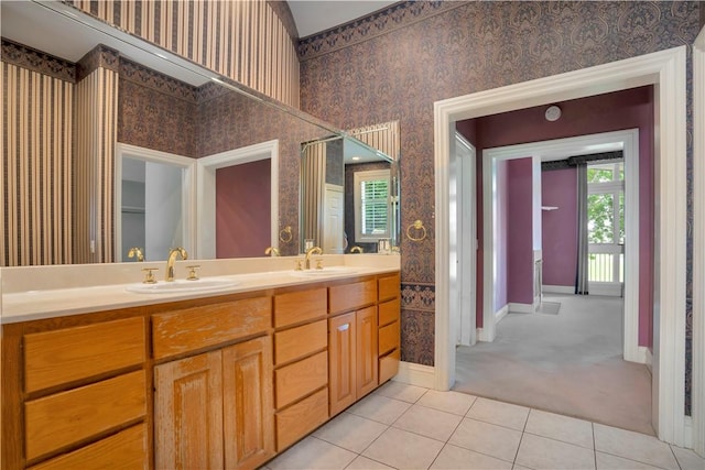 bathroom with baseboards, a sink, tile patterned floors, and wallpapered walls