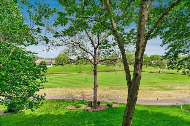 view of home's community with golf course view and a yard