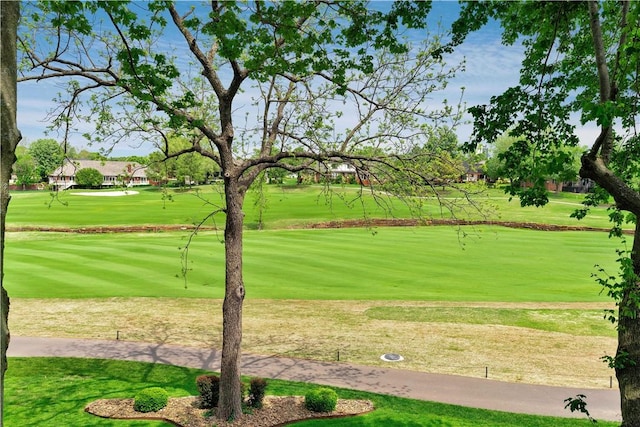 surrounding community featuring a lawn and view of golf course
