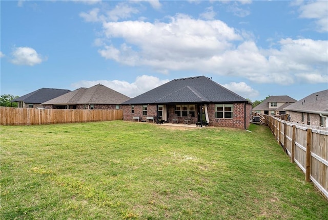 rear view of property with a lawn, a patio, and a fenced backyard