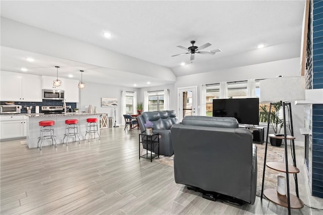 living area with a toaster, a fireplace, light wood-style floors, ceiling fan, and recessed lighting