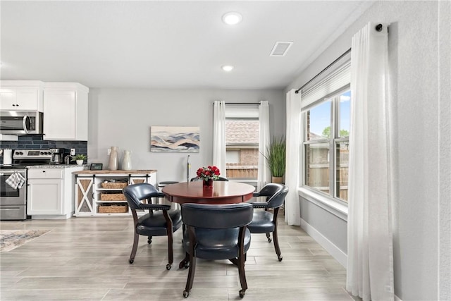 dining room featuring recessed lighting, baseboards, visible vents, and light wood-style flooring