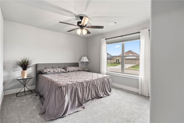 carpeted bedroom with visible vents, a ceiling fan, and baseboards