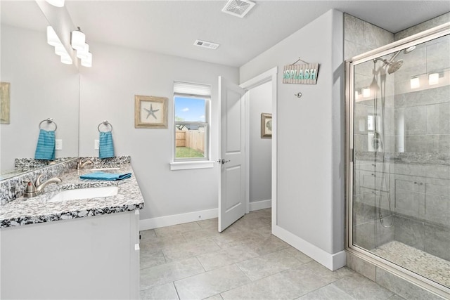 bathroom featuring baseboards, a shower stall, and visible vents