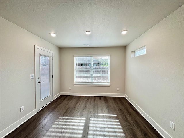 unfurnished dining area featuring recessed lighting, baseboards, visible vents, and dark wood-type flooring
