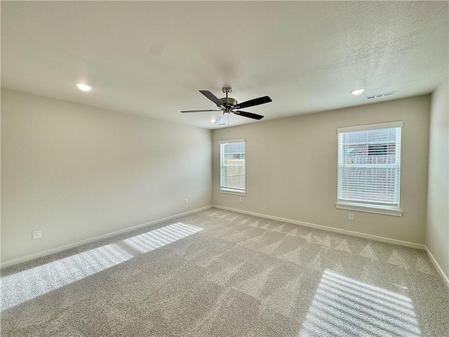 unfurnished room with baseboards, light colored carpet, and visible vents