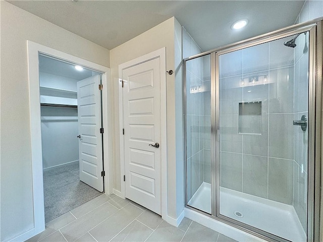 bathroom featuring baseboards, recessed lighting, tile patterned floors, a spacious closet, and a stall shower