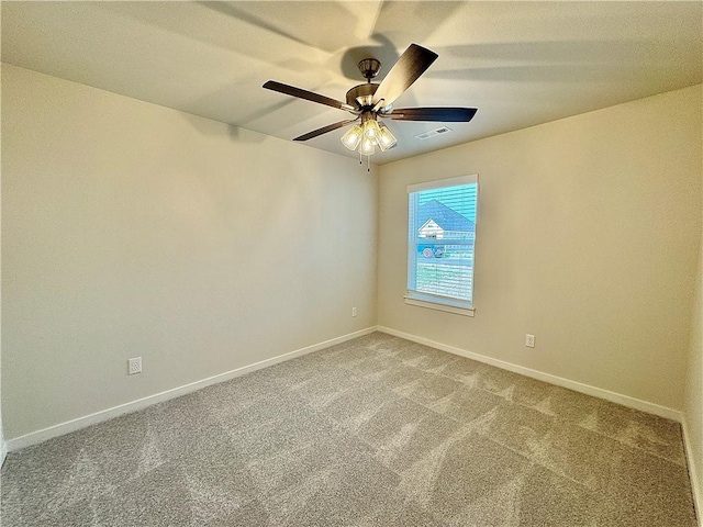 carpeted spare room featuring visible vents, a ceiling fan, and baseboards