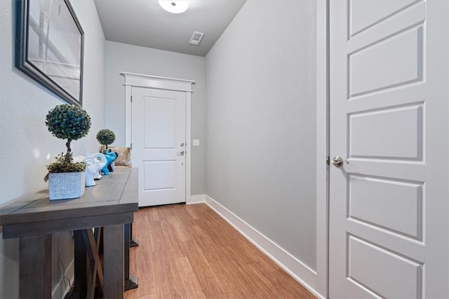 doorway featuring baseboards, visible vents, and light wood-type flooring