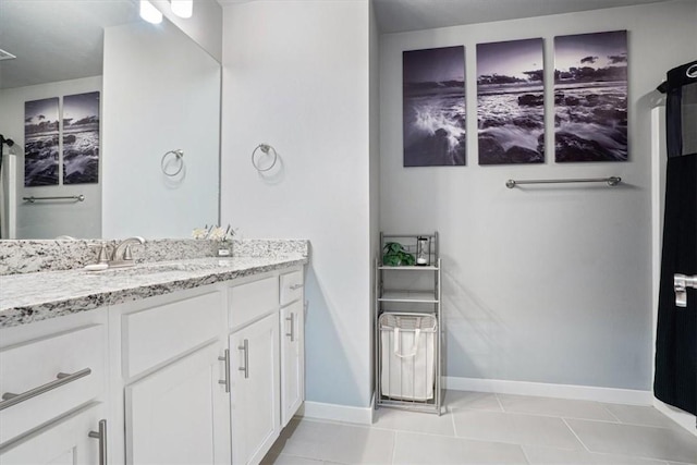 bathroom with baseboards, tile patterned floors, and vanity