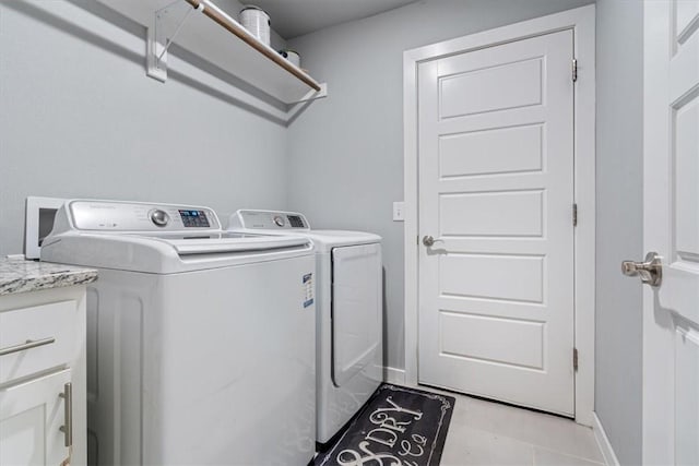 clothes washing area featuring light tile patterned floors, baseboards, laundry area, and washer and dryer