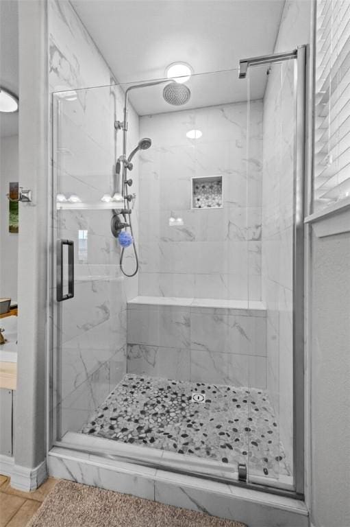 bathroom featuring a marble finish shower