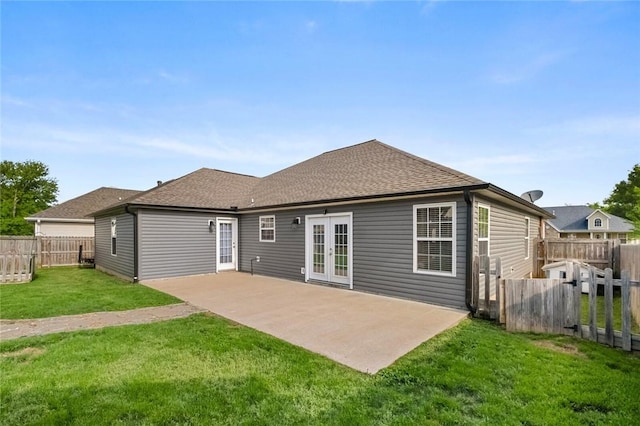 rear view of house featuring french doors, a lawn, a fenced backyard, a patio, and a shingled roof