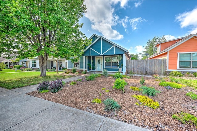 view of front of property with covered porch, fence, and a front yard
