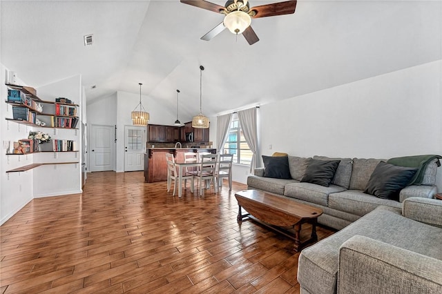 living room with a ceiling fan, baseboards, wood finished floors, lofted ceiling, and visible vents