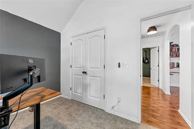 office space featuring baseboards, light wood-style flooring, and lofted ceiling