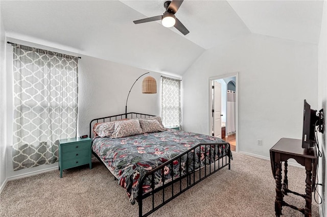 bedroom featuring lofted ceiling, baseboards, ceiling fan, carpet flooring, and ensuite bath