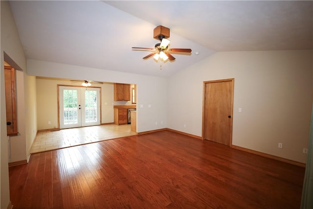 unfurnished living room with ceiling fan, french doors, wood finished floors, baseboards, and lofted ceiling