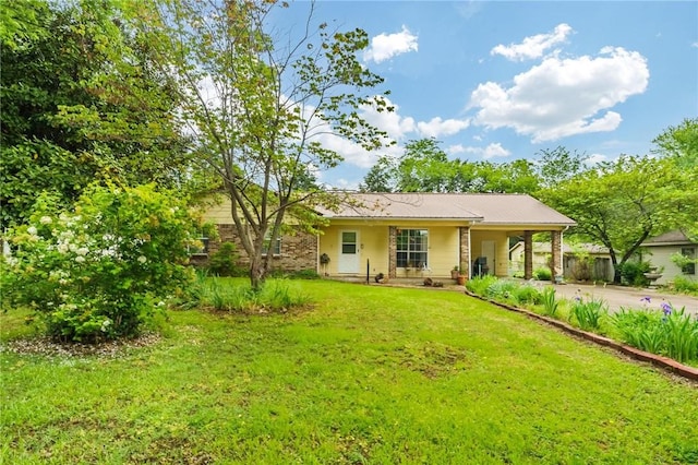 single story home featuring metal roof, driveway, a front yard, and a carport
