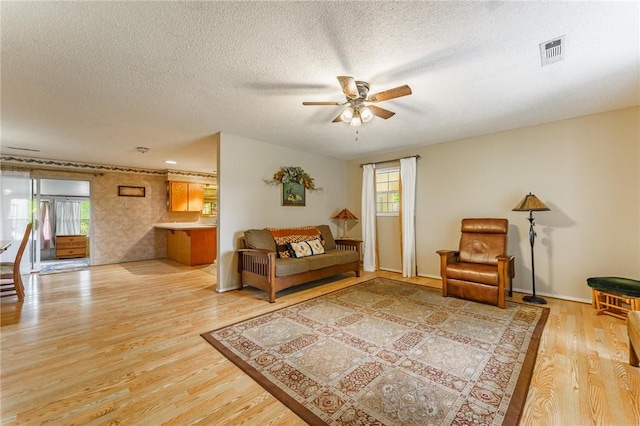 interior space featuring ceiling fan, visible vents, a healthy amount of sunlight, and light wood-type flooring