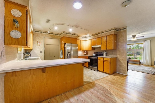kitchen with visible vents, a sink, light countertops, light wood-style floors, and stainless steel appliances