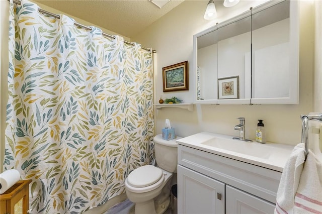 bathroom featuring toilet, a textured ceiling, and vanity