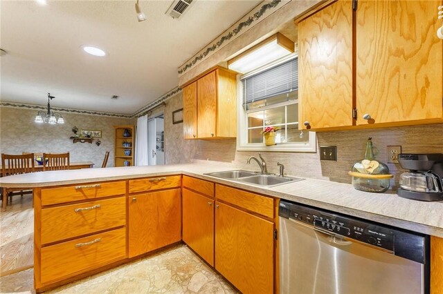 kitchen with light countertops, stainless steel dishwasher, a peninsula, and visible vents