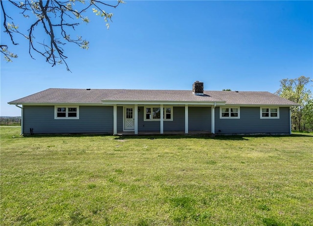 ranch-style home with a chimney and a front lawn