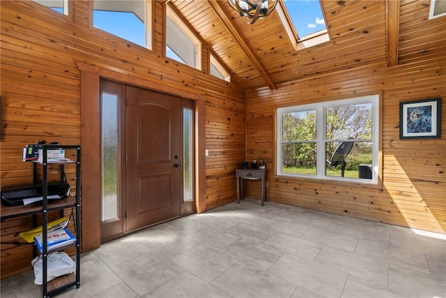foyer with high vaulted ceiling, wood walls, and beam ceiling