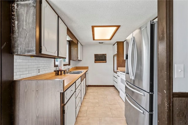 kitchen with decorative backsplash, baseboards, stainless steel refrigerator with ice dispenser, a sink, and white electric stove