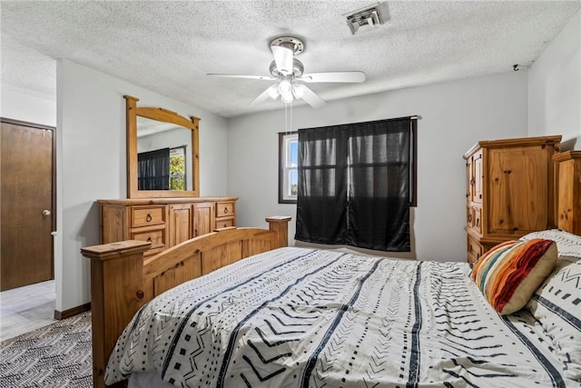bedroom featuring a textured ceiling, ceiling fan, and visible vents