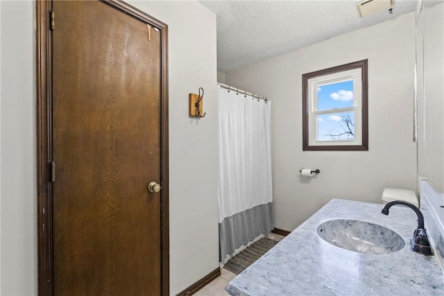 full bathroom with vanity, baseboards, a shower with curtain, and a textured ceiling