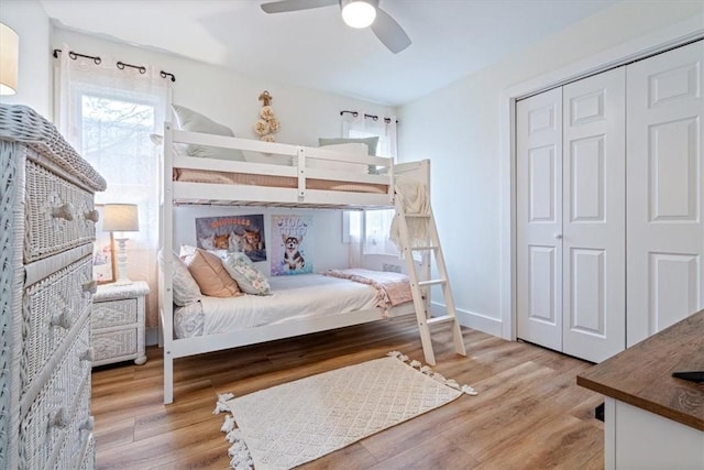 bedroom featuring multiple windows, a ceiling fan, a closet, and light wood finished floors
