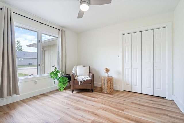 sitting room with a ceiling fan, baseboards, plenty of natural light, and light wood-style flooring