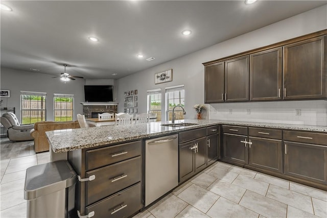 kitchen with a ceiling fan, stainless steel dishwasher, a sink, a peninsula, and open floor plan
