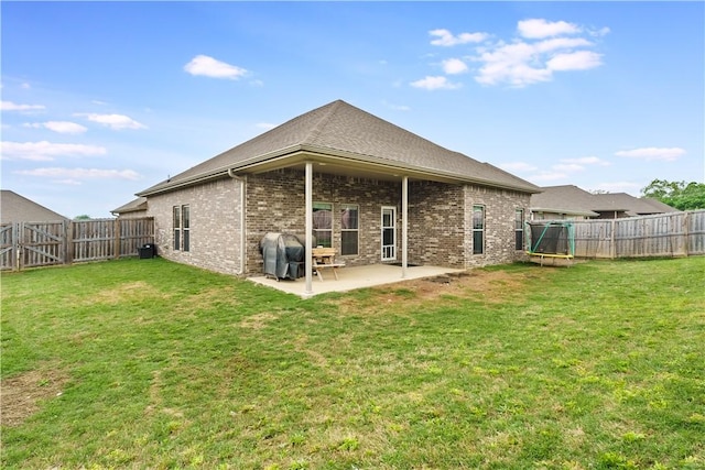 back of property featuring a fenced backyard, a lawn, a patio area, and brick siding