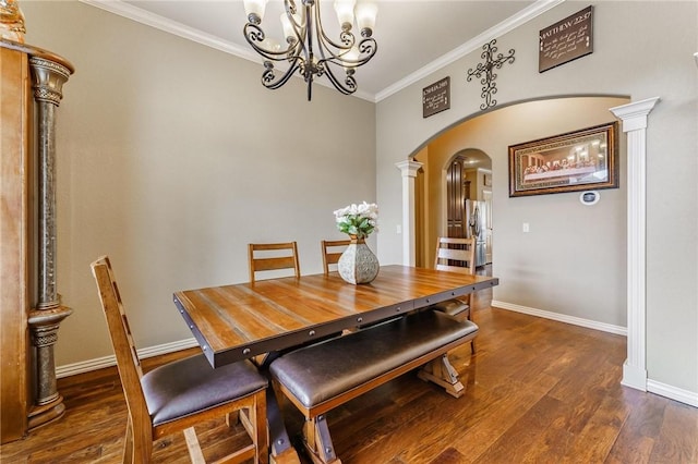 dining space with crown molding, arched walkways, wood finished floors, baseboards, and a notable chandelier