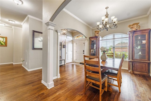 dining area featuring crown molding, arched walkways, a notable chandelier, and hardwood / wood-style flooring