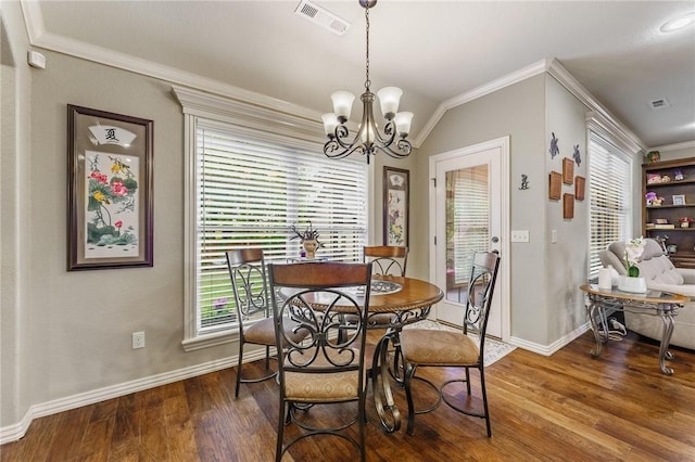 dining space featuring baseboards, visible vents, ornamental molding, and wood finished floors