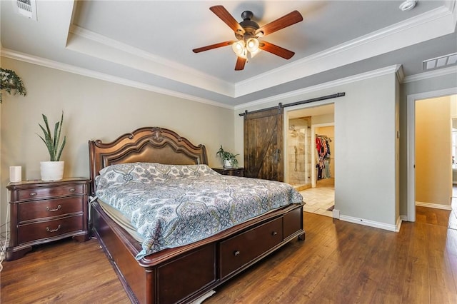 bedroom with a raised ceiling, baseboards, dark wood-style flooring, and visible vents